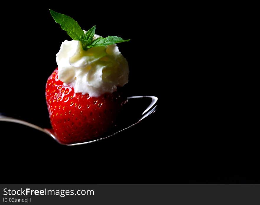 Strawberry with cream and mint on spoon