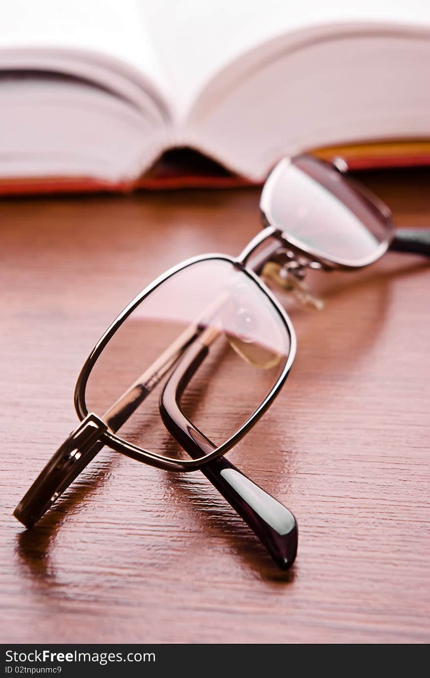 Glasses close up and the open book on a background. Glasses close up and the open book on a background