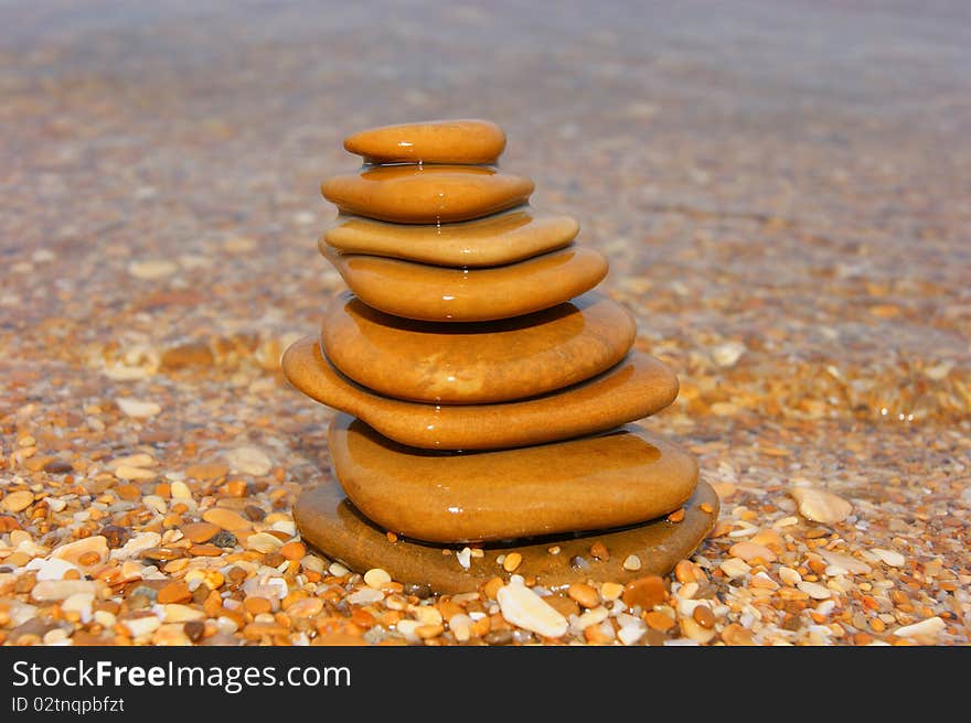 Stones on seacoast. A pyramid from stones. Flat sea stones. A pyramid on a beach.