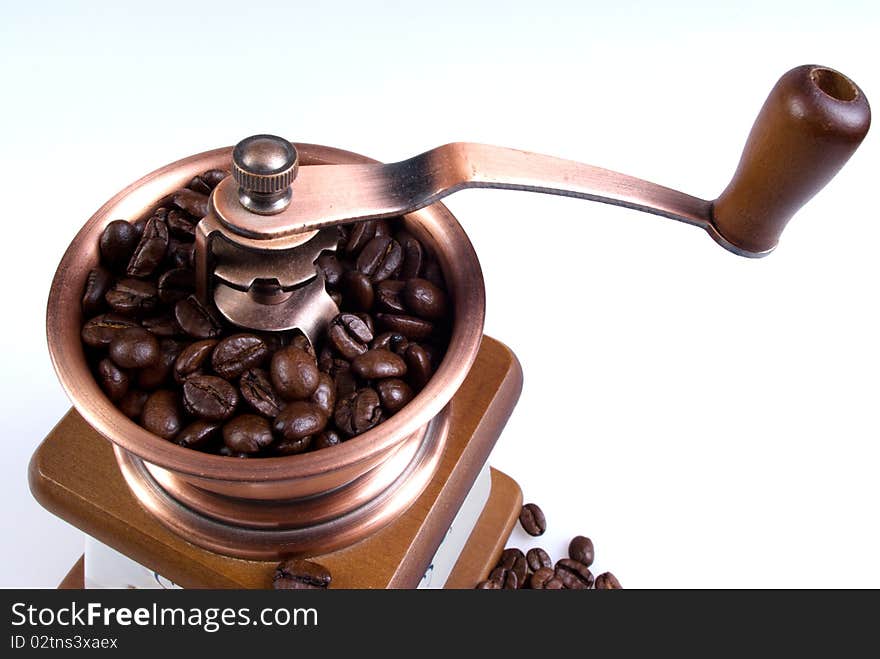 Clouse-up of ancient coffee grinder with coffee grains