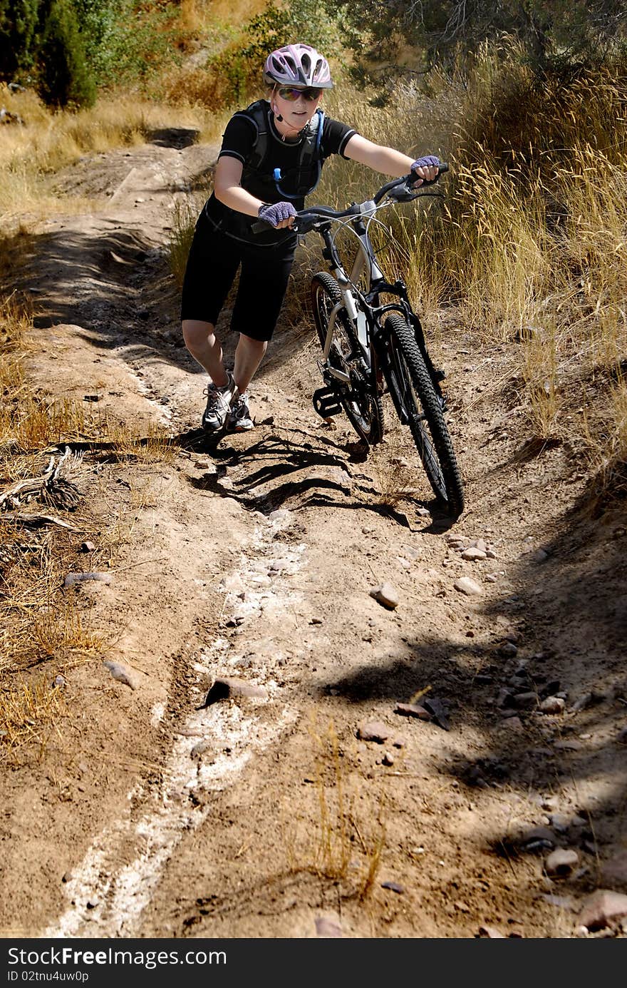 Young Woman Riding Mountain Bike in Wilderness. Young Woman Riding Mountain Bike in Wilderness