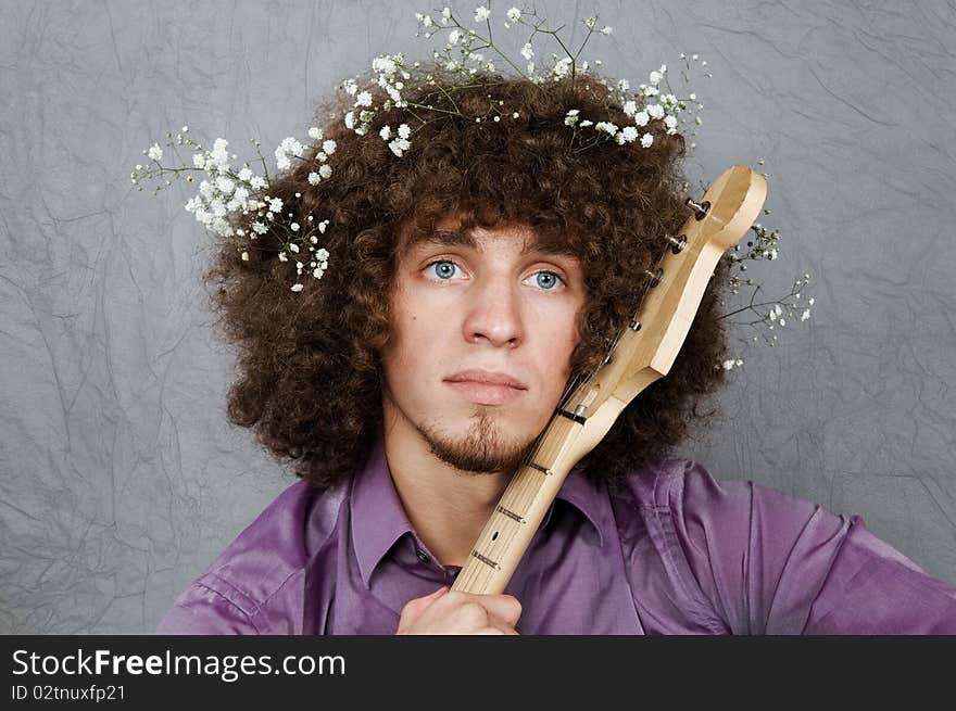 The young guy with curly hair and a guitar in hands. An image of the enamoured romanticist.