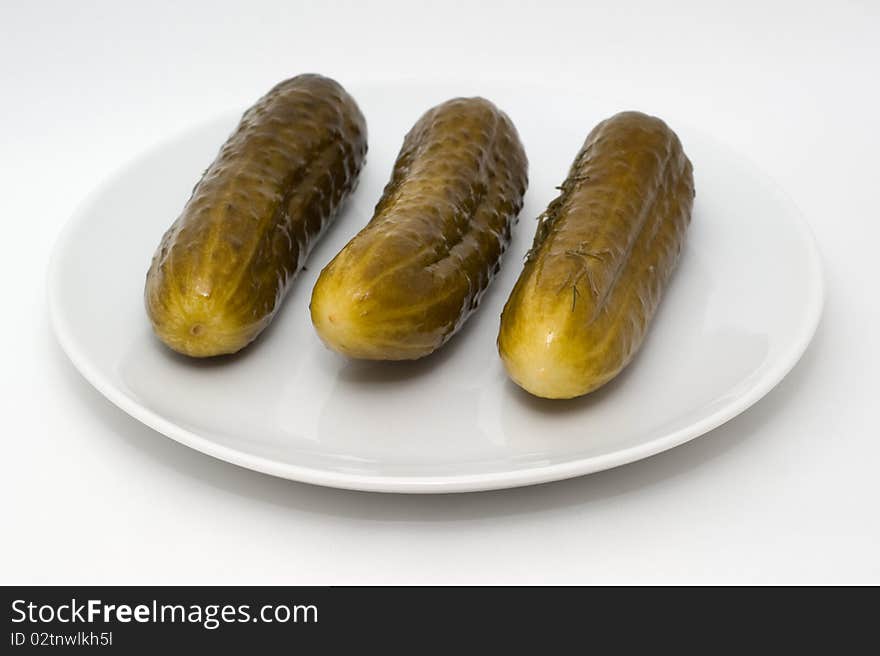 Homemade salted cucumber on a plate on a white background