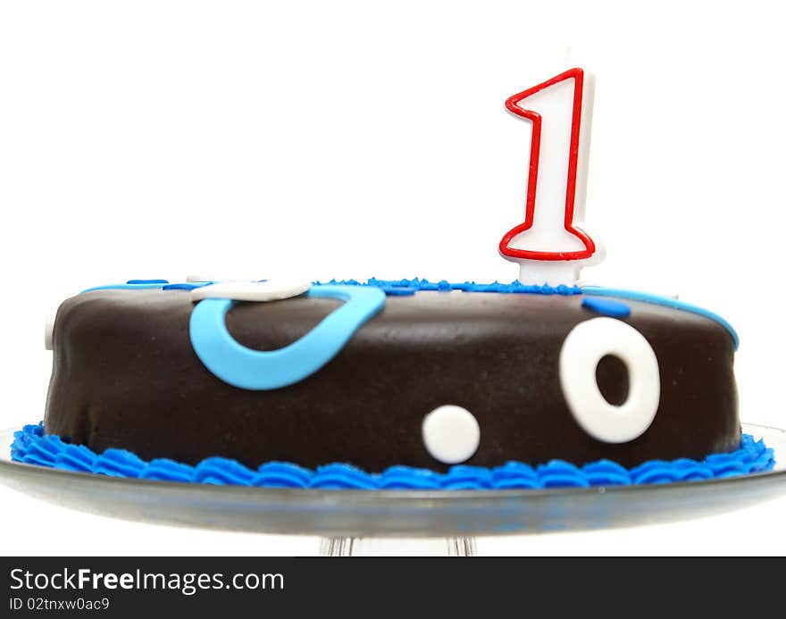 A cake decorated in blue has a number one candle to celebrate that one year mark. A cake decorated in blue has a number one candle to celebrate that one year mark.