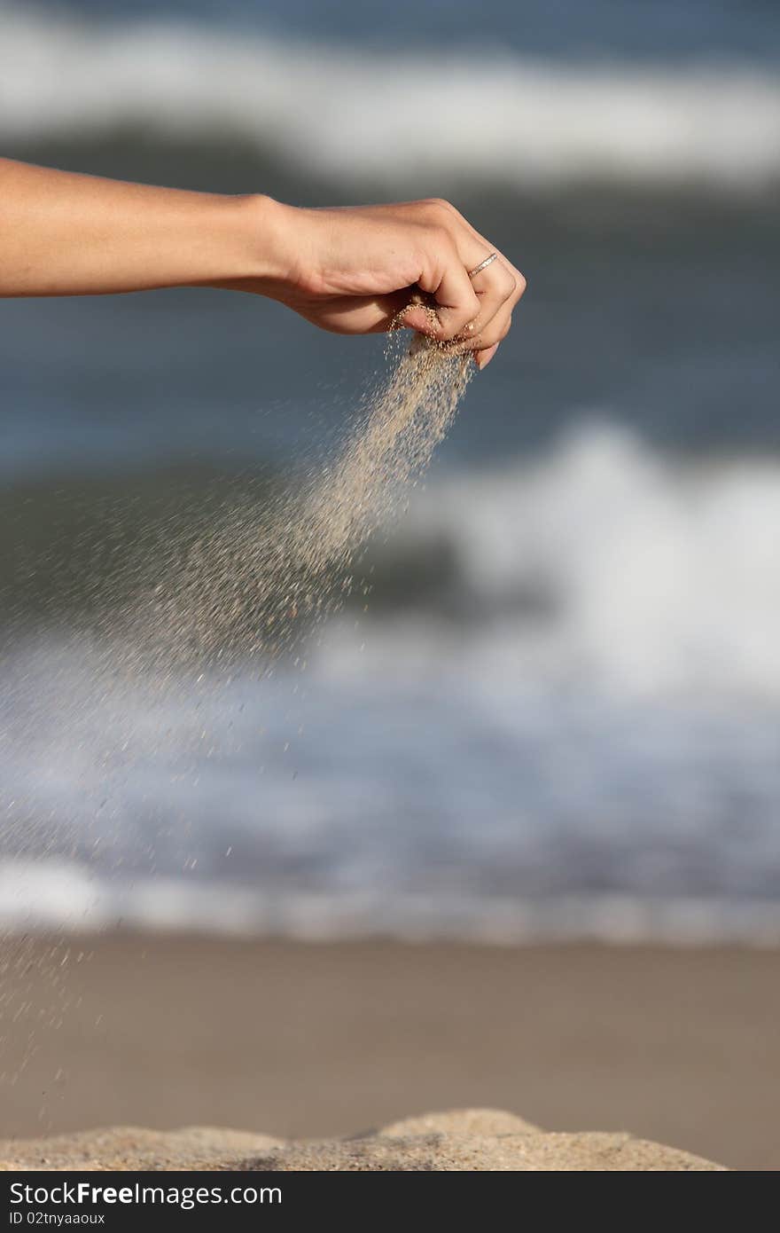 hand pours the sand