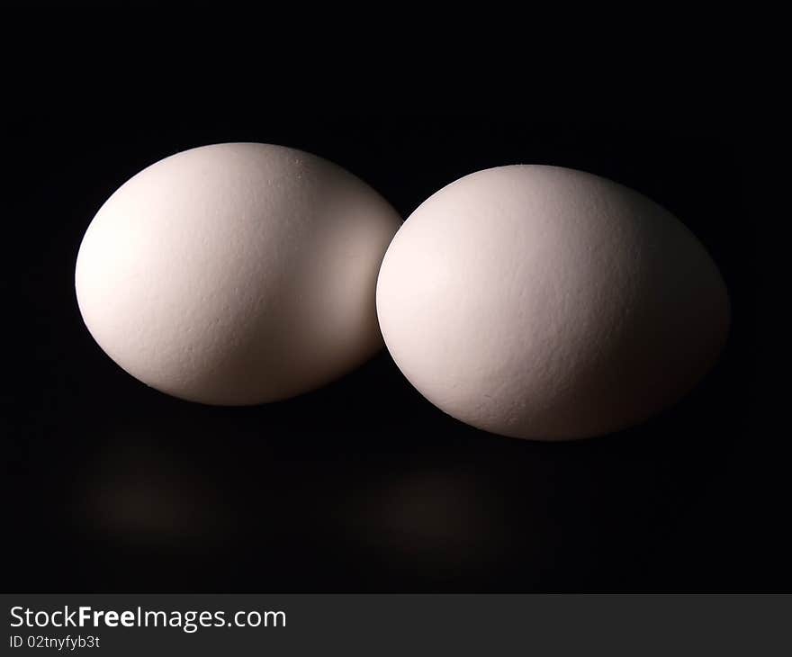 Two eggs on black background