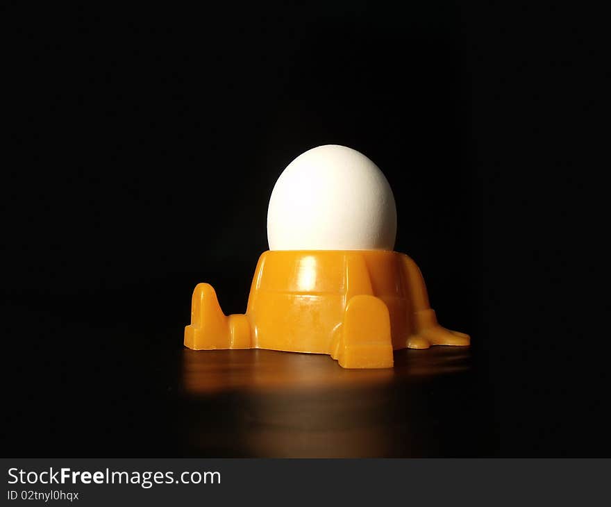 Egg with mans face on black background