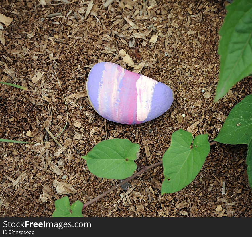 Colorful painted rock in a flower garden. Colorful painted rock in a flower garden.