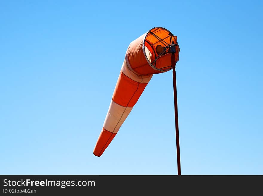 A windsock set against a clear blue sky. A windsock set against a clear blue sky