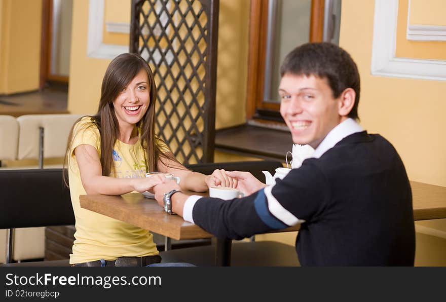 Positive smiling pair sit in cafe