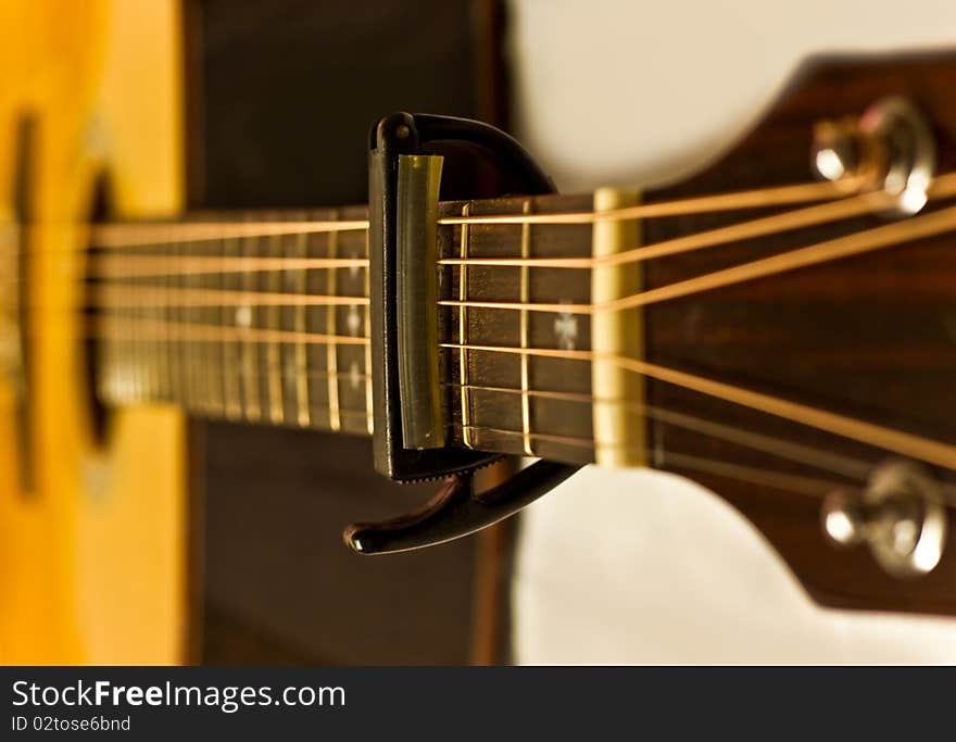 The capo on an acoustic guitar fingerboard. The capo on an acoustic guitar fingerboard.