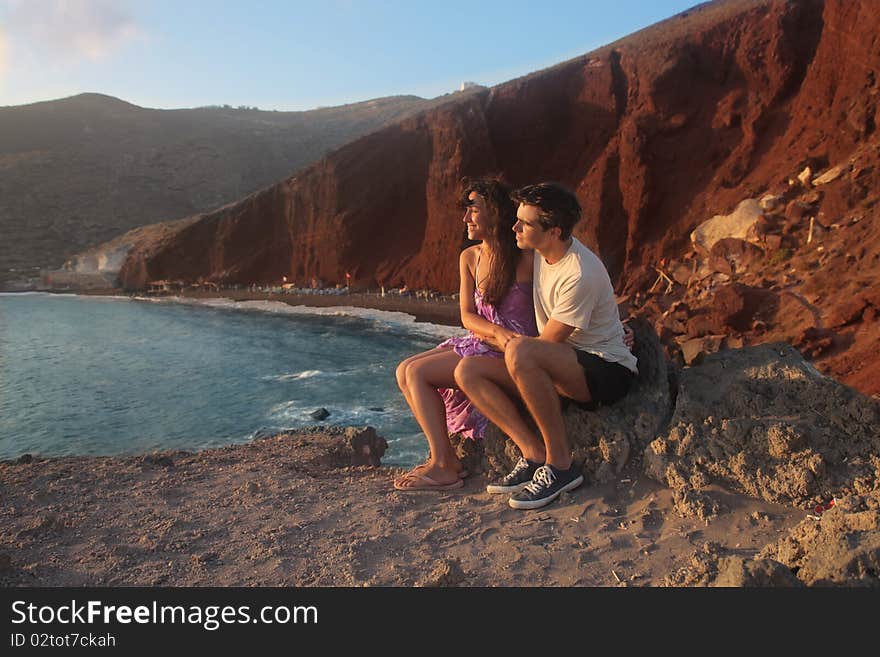 Young couple lokking at a sunset on the beach. Young couple lokking at a sunset on the beach