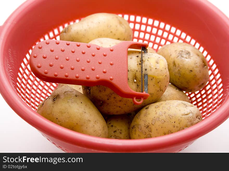 Raw potatoes in the kitchen sieve. Raw potatoes in the kitchen sieve