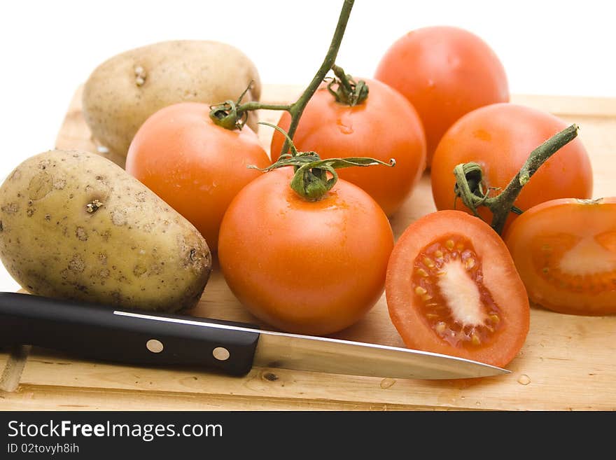 Tomatoes and potatoes with knife. Tomatoes and potatoes with knife