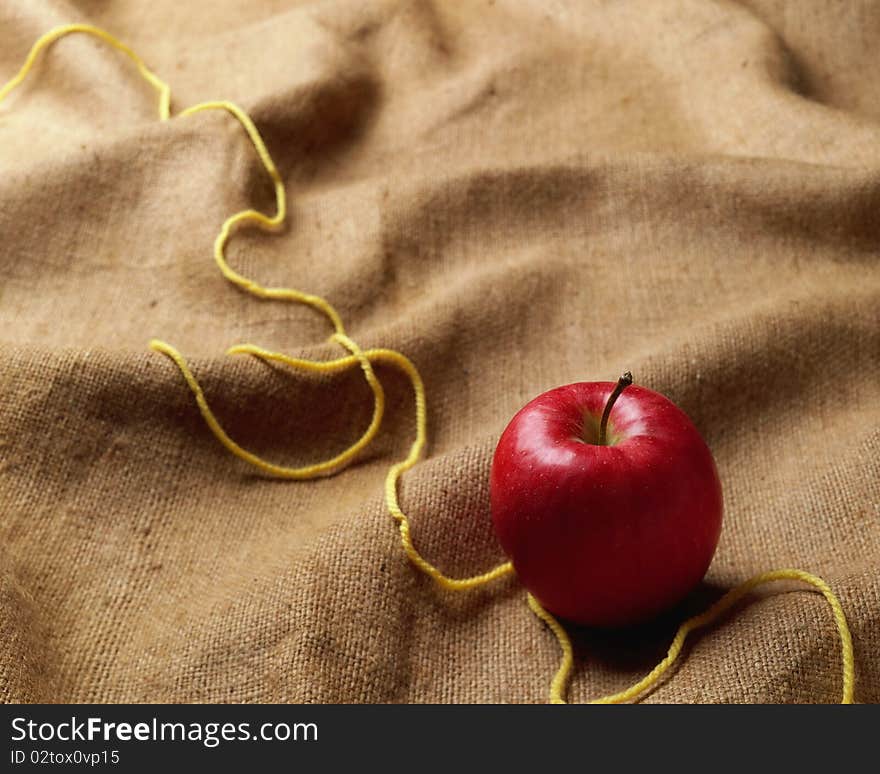 Apple on a towel, a yellow thread