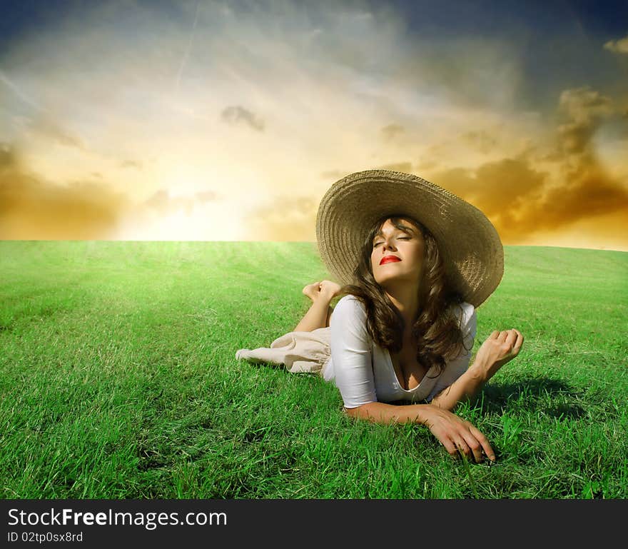 Beautiful woman lying on a green meadow in the sun. Beautiful woman lying on a green meadow in the sun