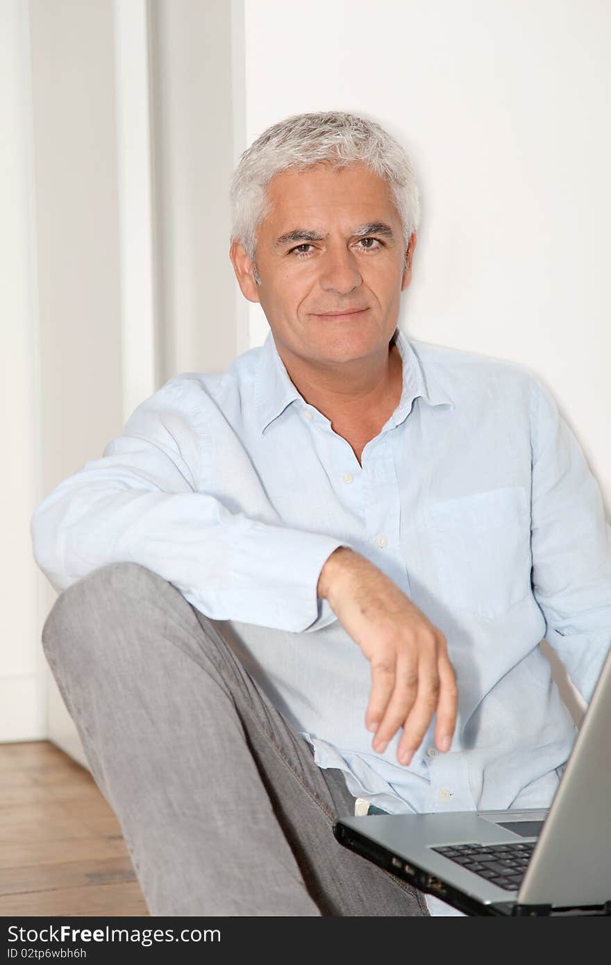 Man sitting on the floor with laptop computer. Man sitting on the floor with laptop computer