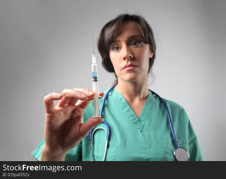 Female doctor holding a syringe. Female doctor holding a syringe