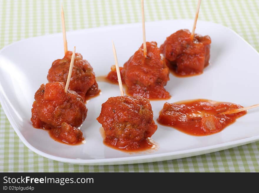 Meatball appetizer covered with tomato sauce on a plate