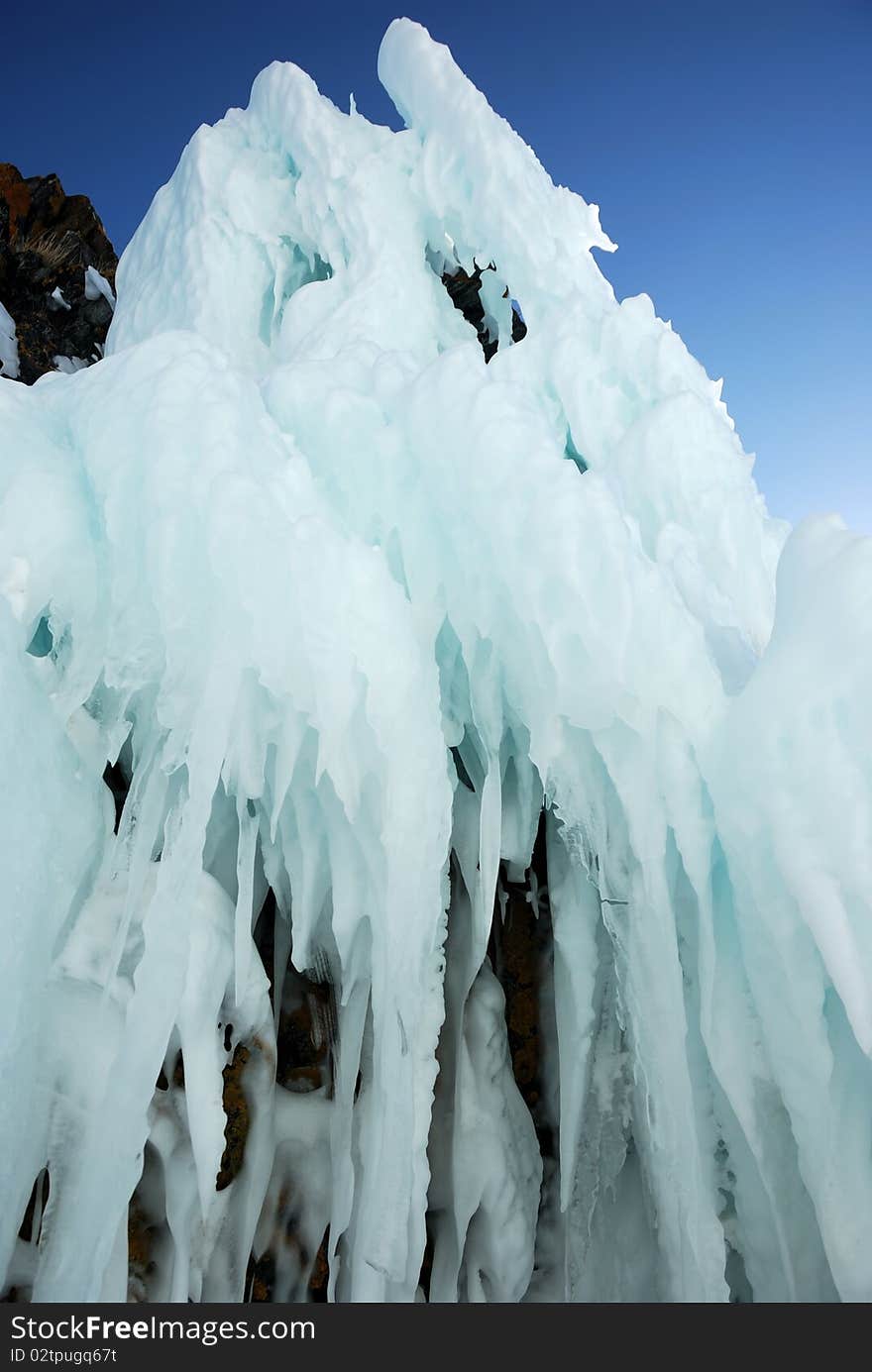 Ice-covered cape rocks of the lake shore with icicles. Ice-covered cape rocks of the lake shore with icicles