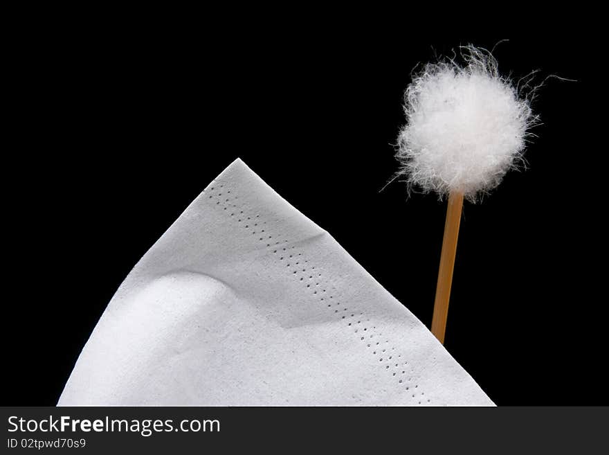 Corner of a white tissue and fluffy cotton ball, on black background. Corner of a white tissue and fluffy cotton ball, on black background.