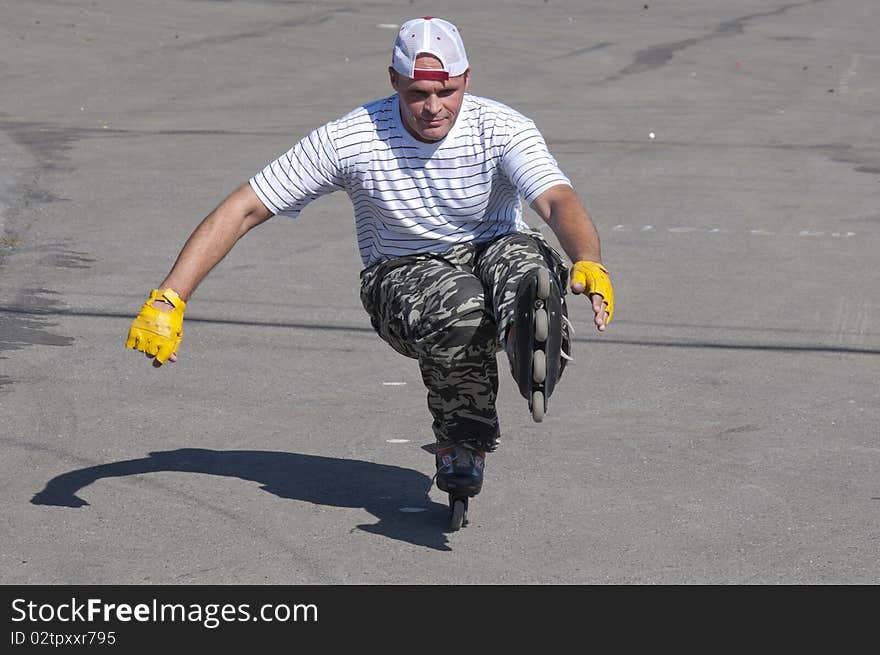 The man goes for a drive on roller skates in a sun