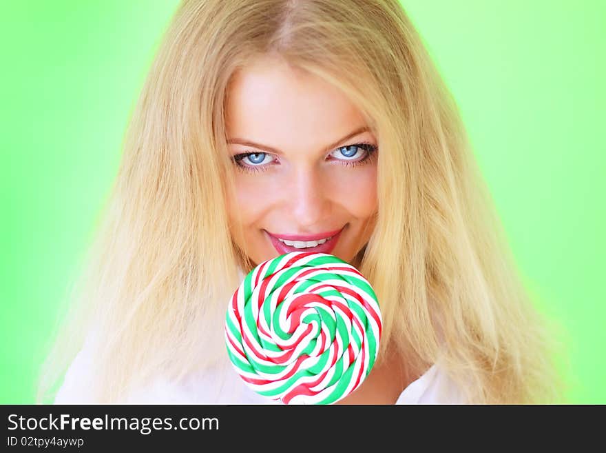 Beautiful girl holding lollipop on a light background