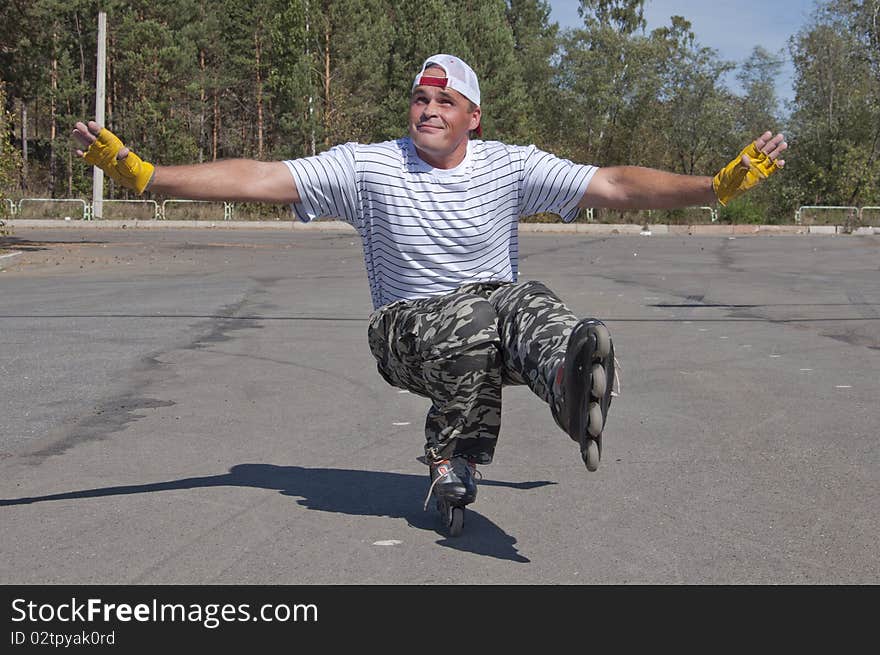 The man goes for a drive on roller skates in a sun