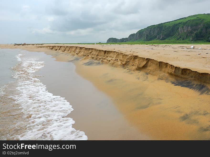 Sand beach view with wavy sea and cloudy sky. Sand beach view with wavy sea and cloudy sky