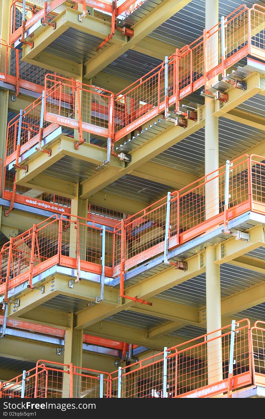 Image of a crane working on construction of a building under the blue sky. Image of a crane working on construction of a building under the blue sky