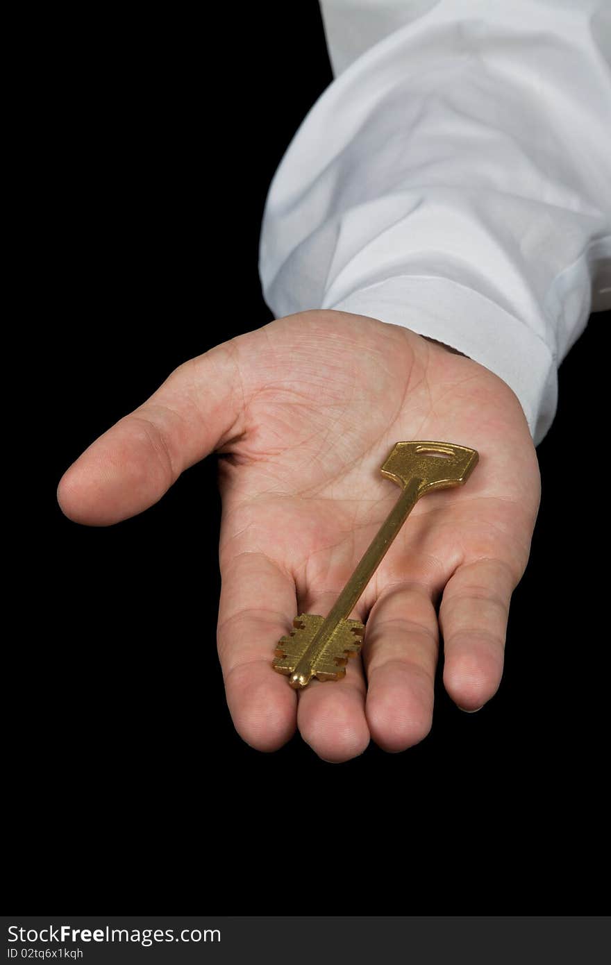 Businessman holding key of success isolated on the black background