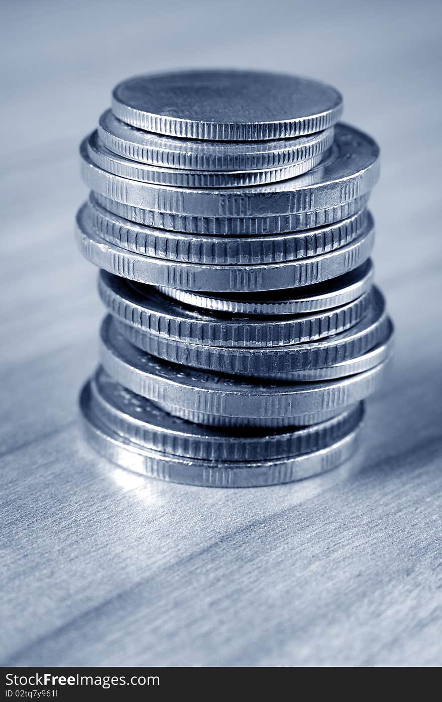 Close up column of coins in metal look on wooden table