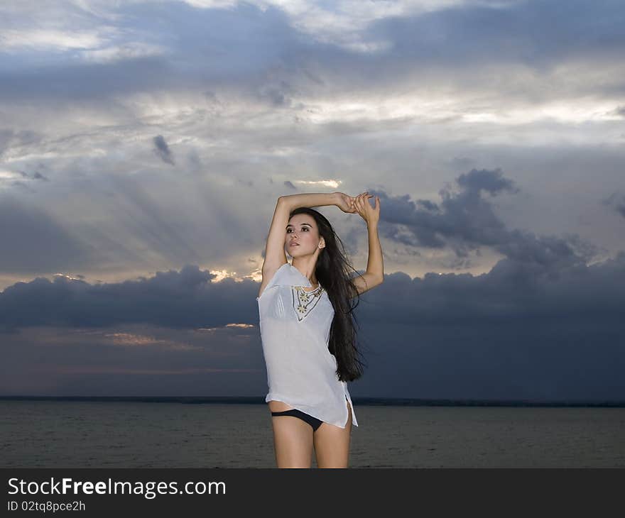 brunette woman over dusk sky at sunset