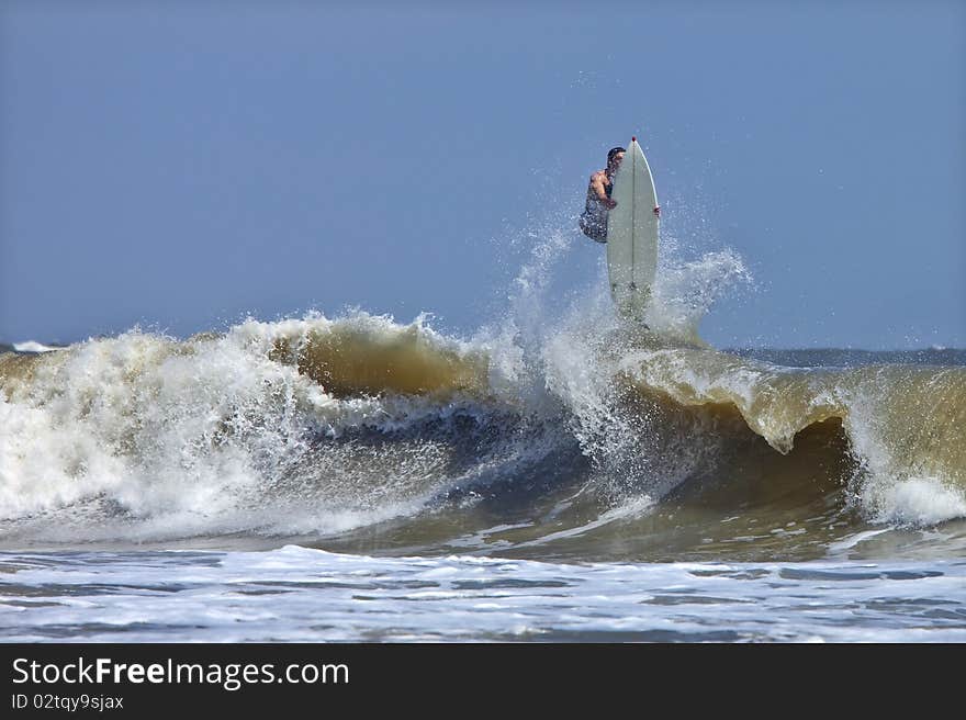 Surfer getting big air and wiping out in rough atlantic surf. Surfer getting big air and wiping out in rough atlantic surf