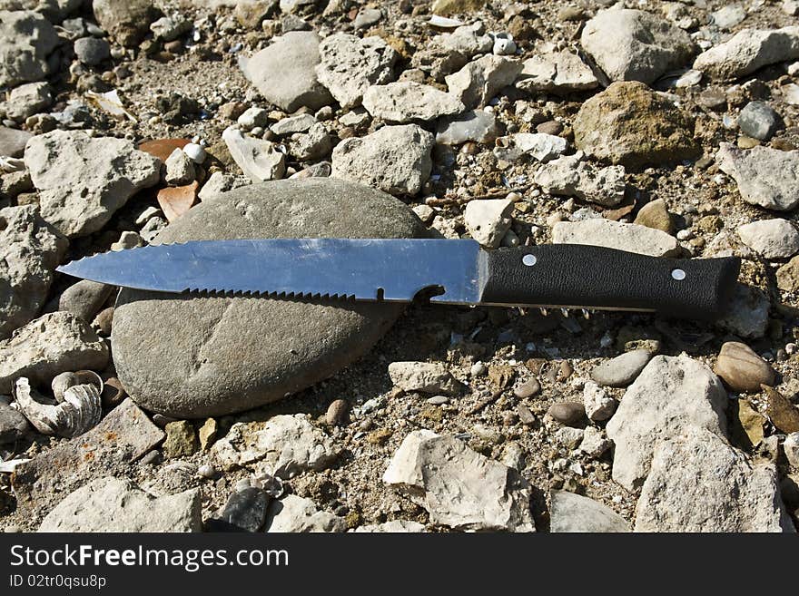 Knife lying on the stones without the cover. Knife lying on the stones without the cover