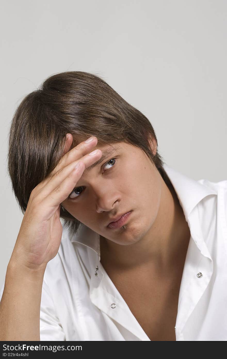 Closeup portrait of a upset young man with hand on his head