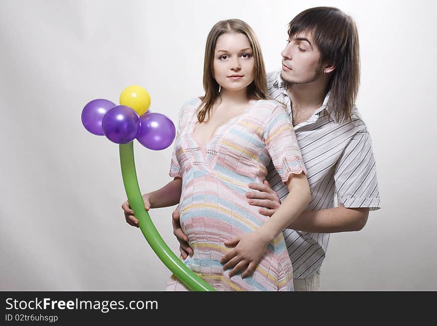 Happy flying pregnant couple holding balloon. Happy flying pregnant couple holding balloon