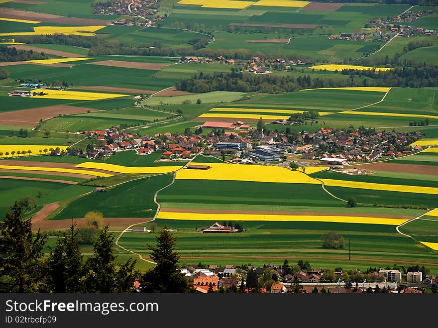 Fontaines village in the middle of Ruz Valley surrounded by fezlds and farms, Cernier city is at foreground and just behind wa can see Engollon aglomeration