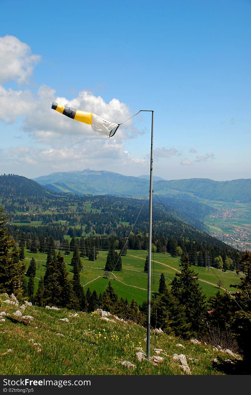 Wether-cock on Tete de Ran meteo station showing the wind dirrection, Jura hills and the sky is at background