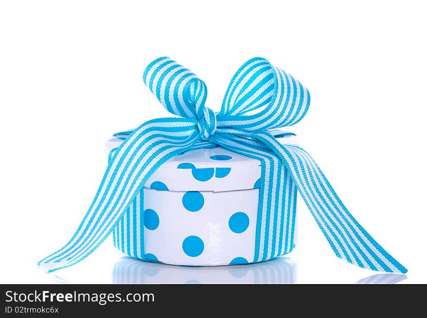 A blue white dotted giftbox with a striped ribbon isolated over white