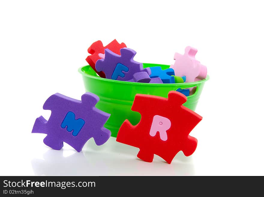 A green plastic tray with an instructive colorful  ABC puzzle isolated over white. A green plastic tray with an instructive colorful  ABC puzzle isolated over white