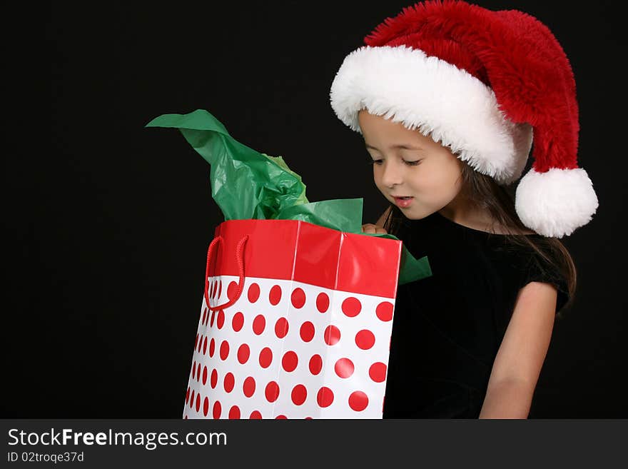 Cute little brunette girl wearing a christmas hat. Cute little brunette girl wearing a christmas hat