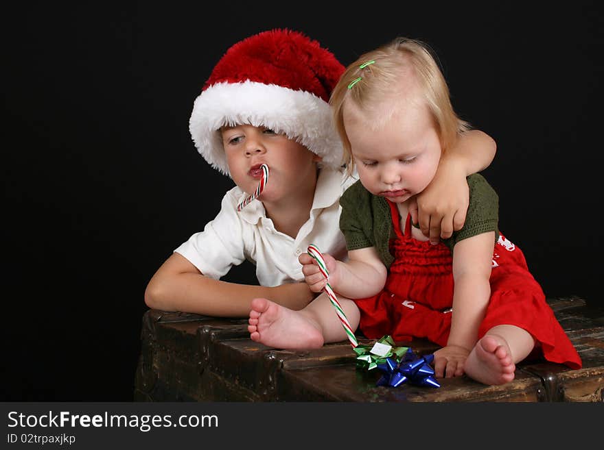 Christmas brother and sister eating Candy Canes. Christmas brother and sister eating Candy Canes