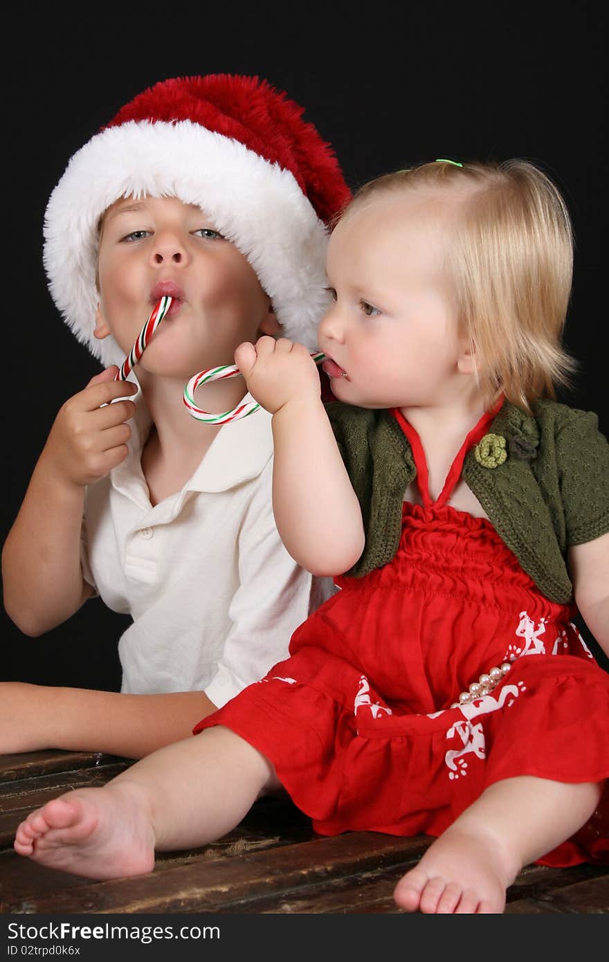 Christmas brother and sister eating Candy Canes. Christmas brother and sister eating Candy Canes