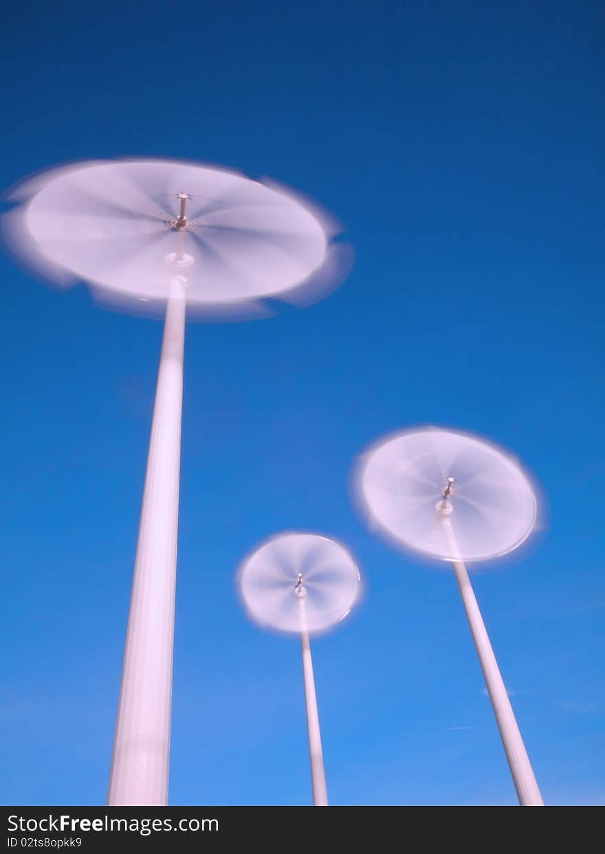 Motion blade of modern win turbine in windy day with blue sky.