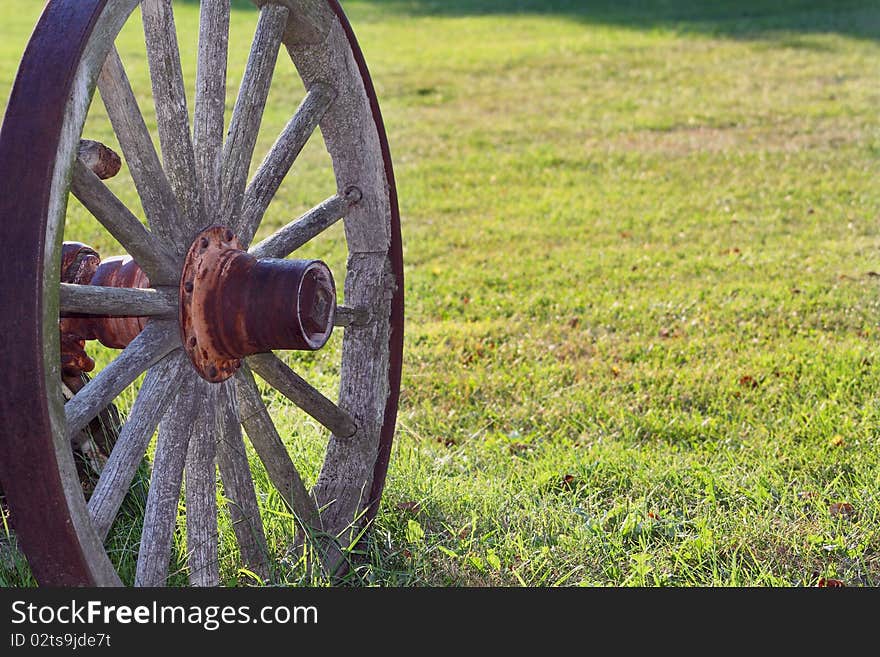 Rustic wooden wagon wheel parked on grass