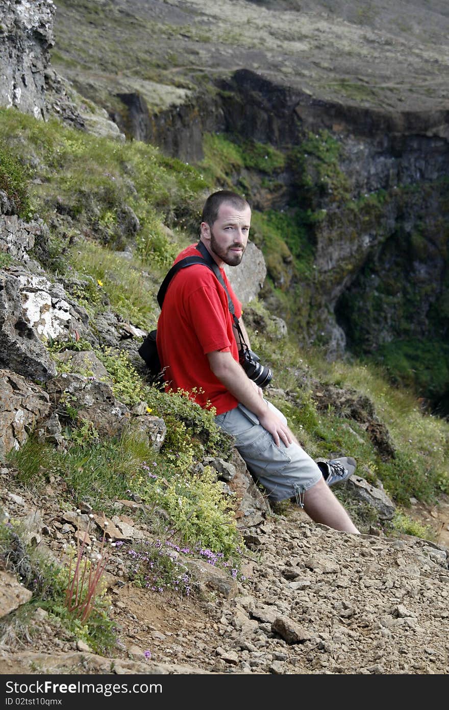 Young male traveller, photographer resting and enjoying the beautiful view of mountains in Iceland