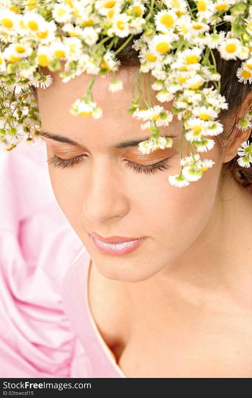 Beatiful girl with a flower wreath in the field