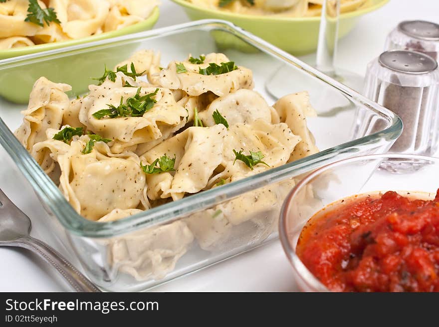 Serving of healthy stuffed tortellini pasta with herbs and tomato sauce