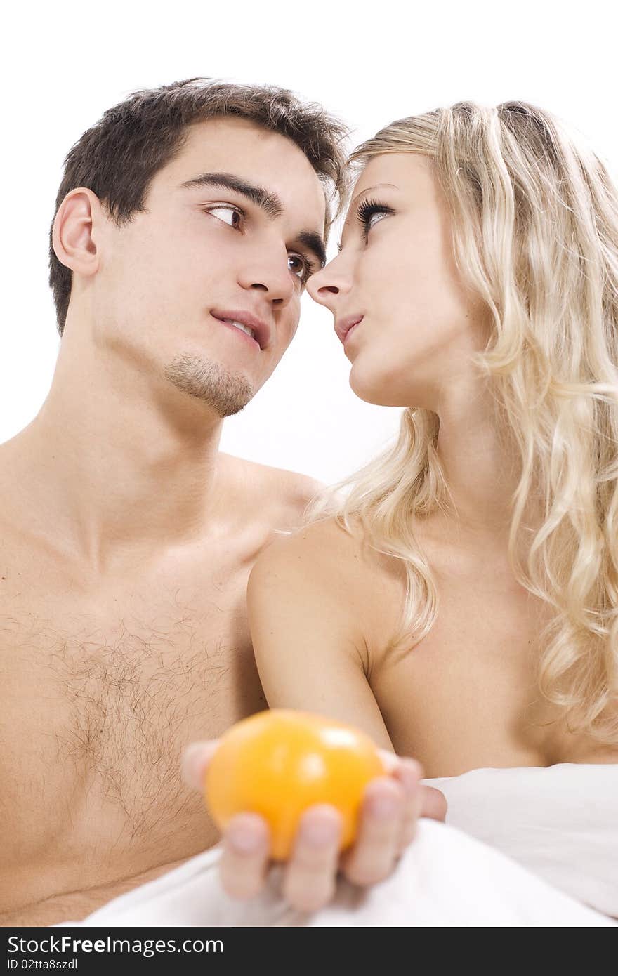 Young couple enjoying fruit breakfast in bed. Young couple enjoying fruit breakfast in bed